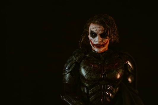 Man in joker costume with dark makeup and armor